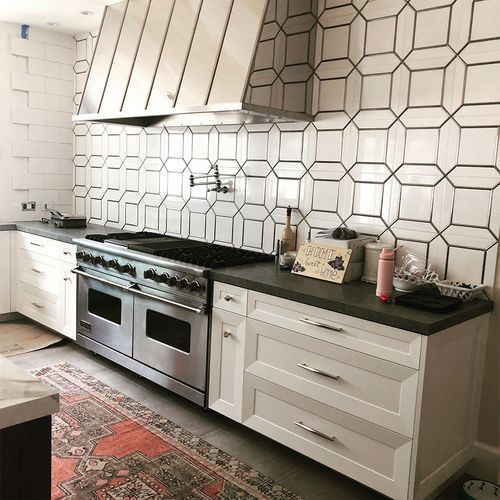 A kitchen with stainless steel appliances and white cabinets.