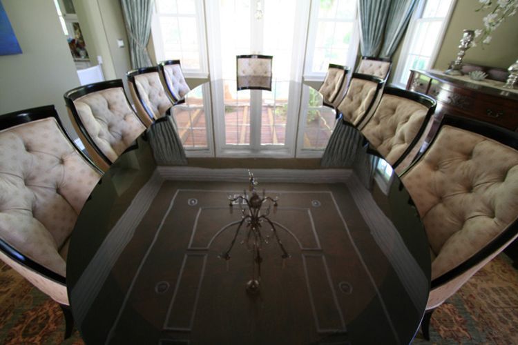 A dining room with a long table and chairs and a chandelier.
