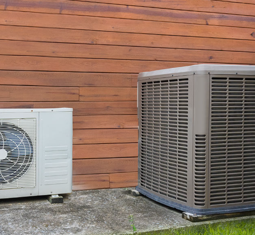 A man wearing a hard hat is working on an air conditioner.