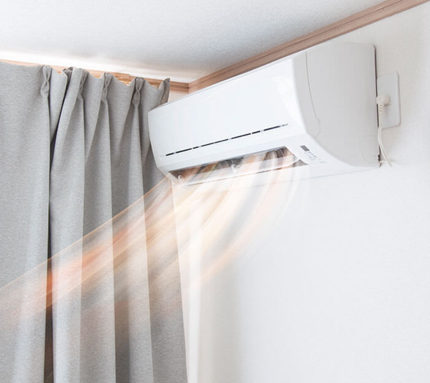 A man wearing a hard hat is working on an air conditioner.