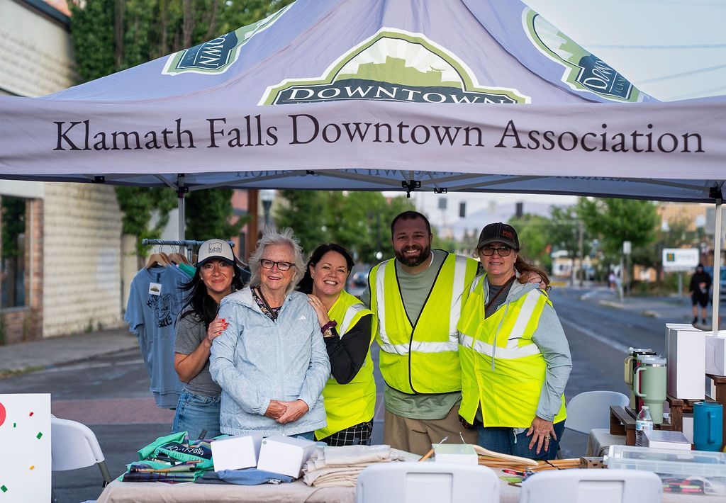 A woman is sitting at a table with a sign that says muffin mondays.