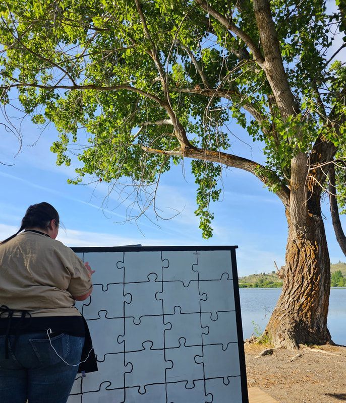 A woman is standing in front of a large puzzle board