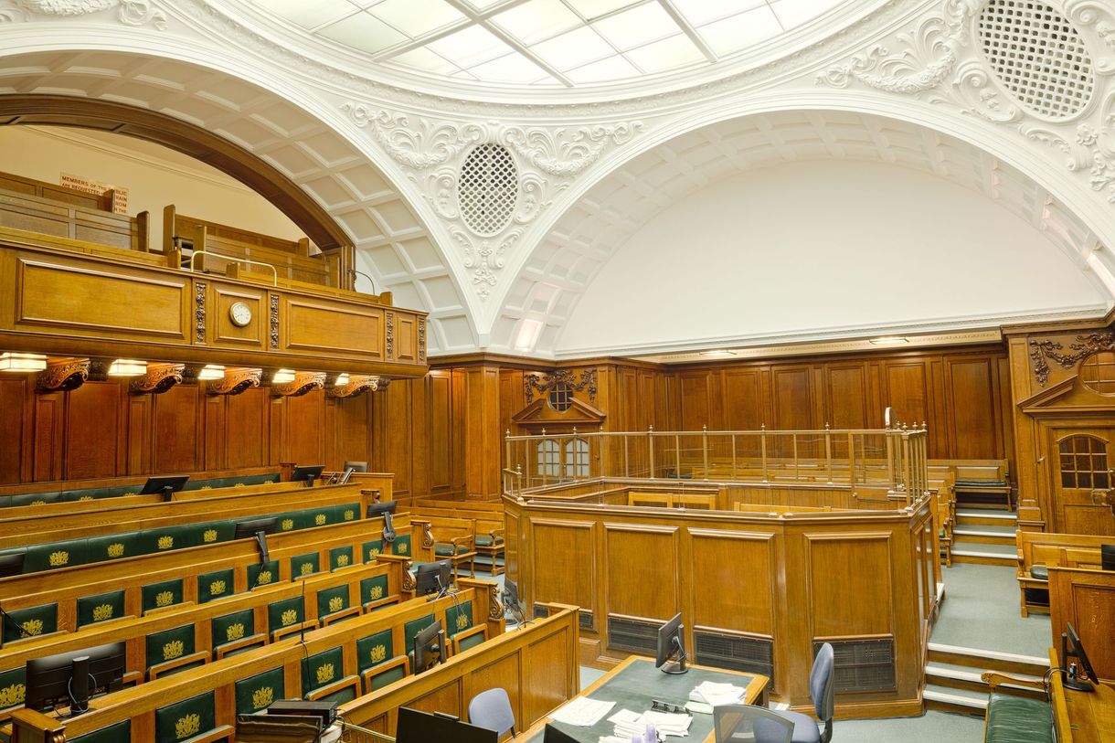 A woman is standing in front of a jury in a courtroom.