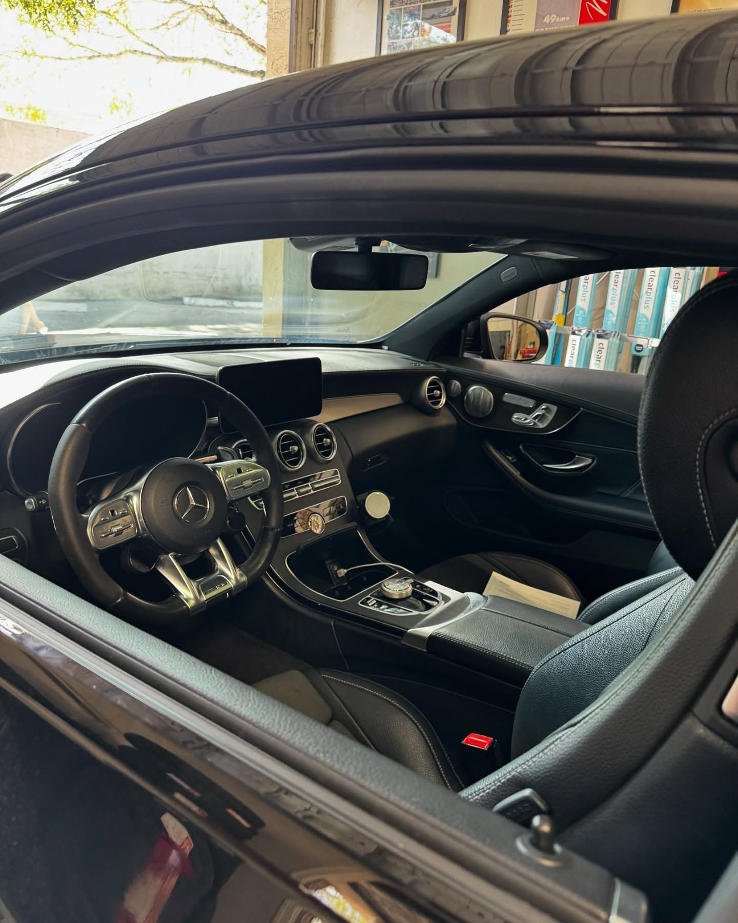 Interior view of a black Mercedes-Benz, showcasing the dashboard, steering wheel, seats, and center console.