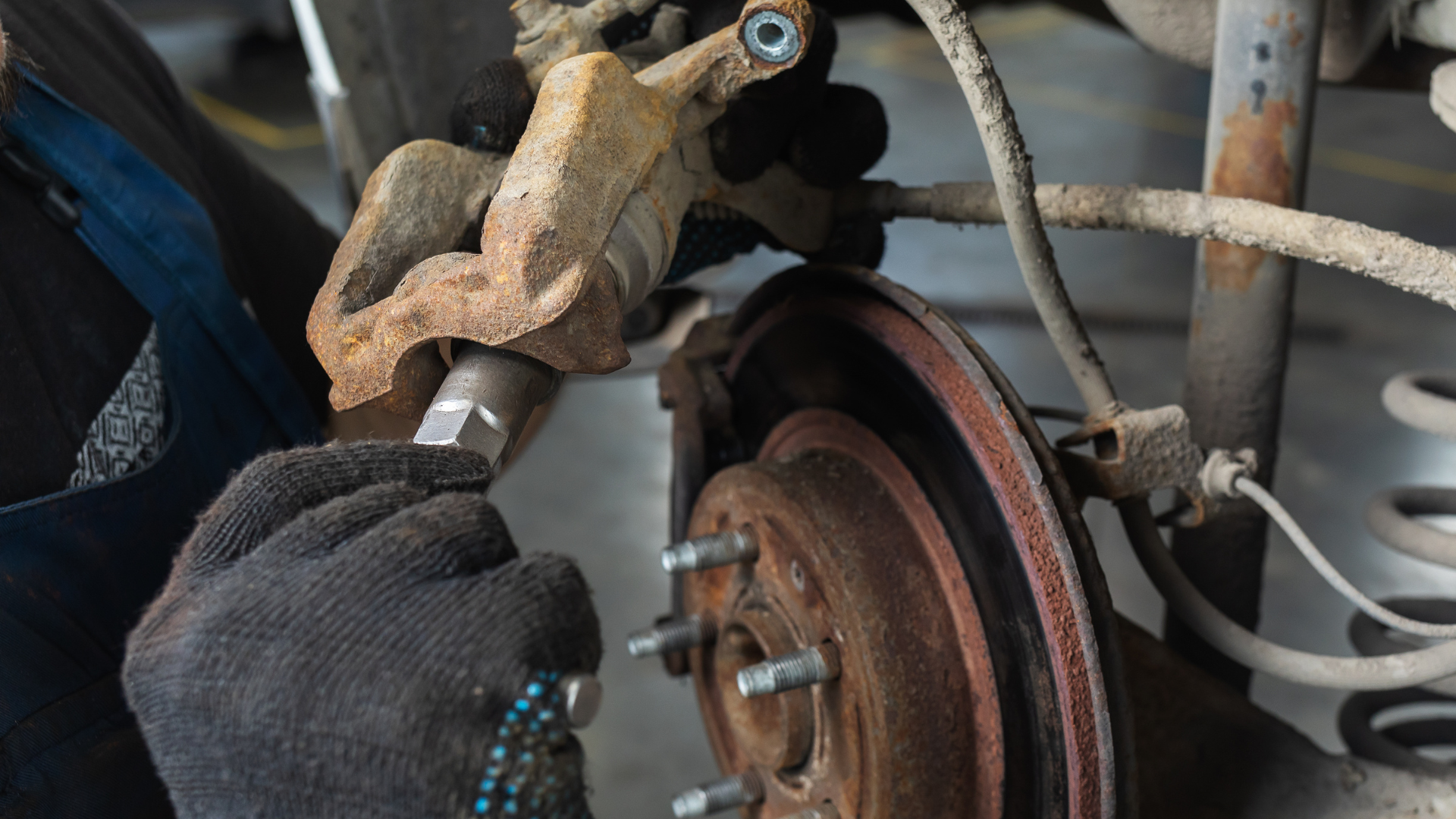 Car tire changed; spare tire, jack, and lug wrench on ground. Black car and wheel.