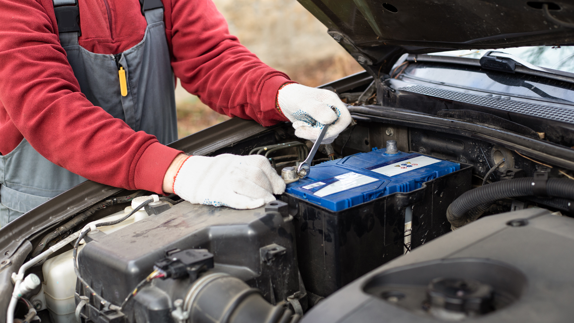 Pouring red fluid from a container into a car engine compartment.