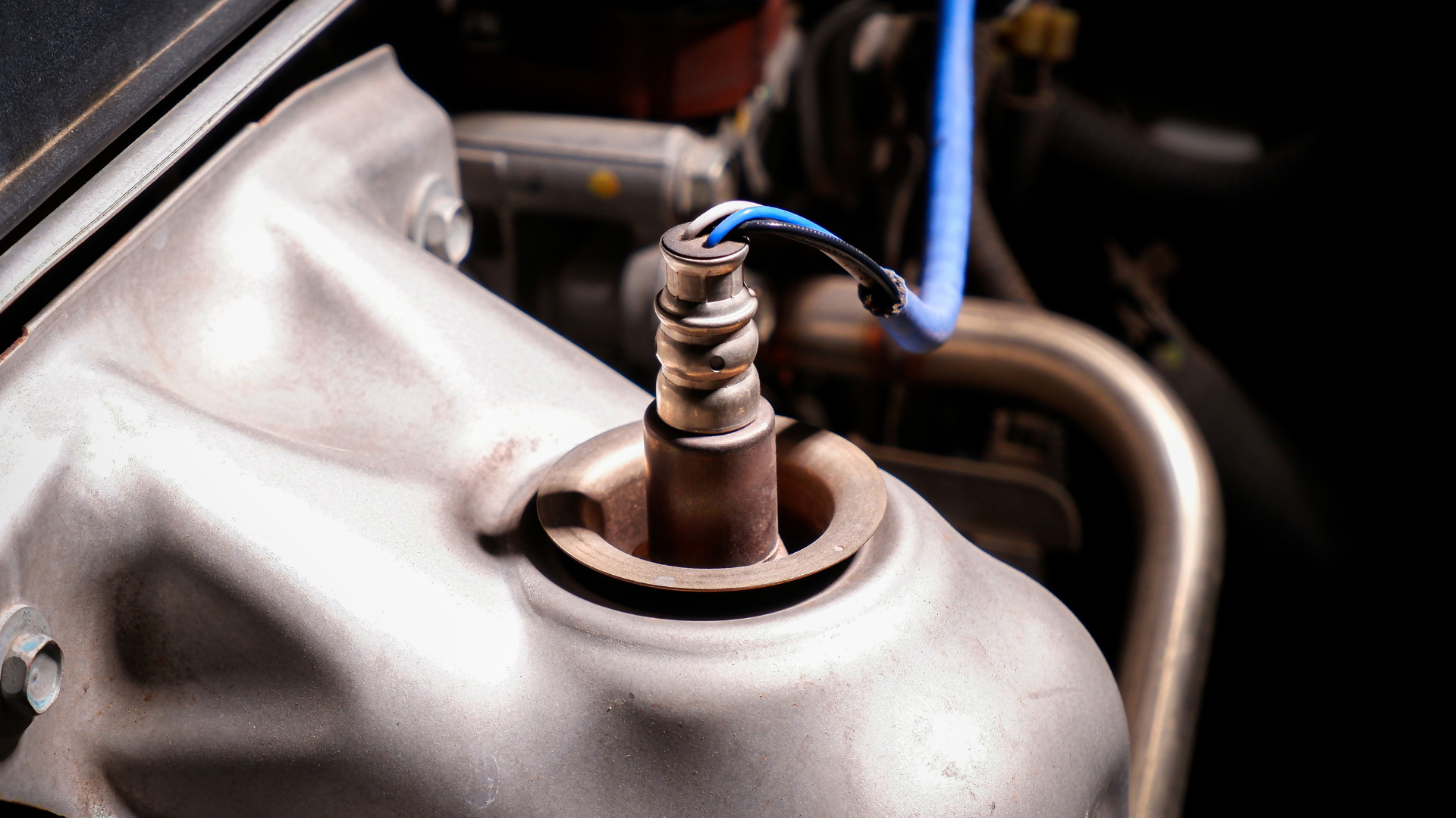 A person cleaning a black car engine in a garage.