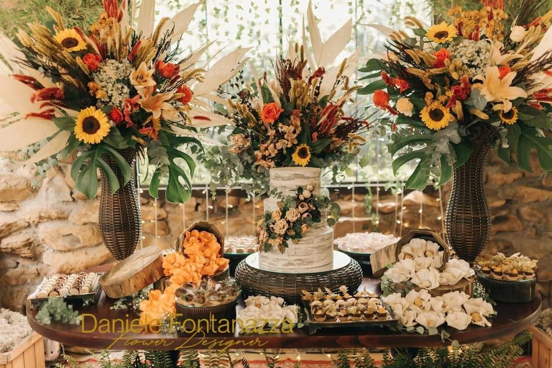 Centrotavola floreale con torta e dessert, stile rustico, colori caldi.