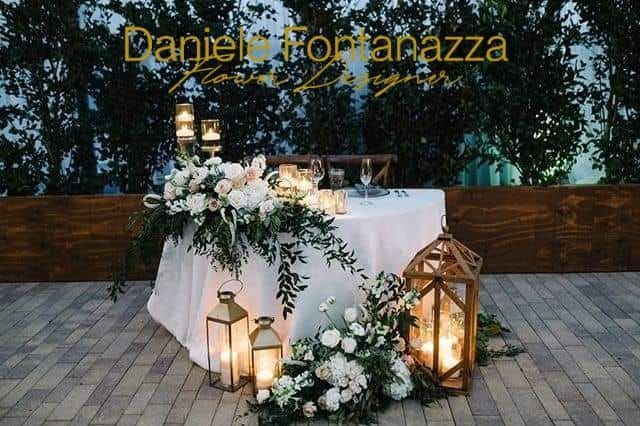 Elegante apparecchiatura da tavola con fiori bianchi, lanterne e candele.