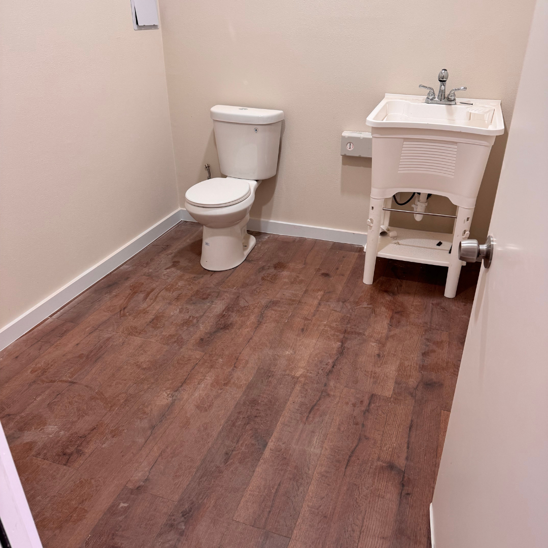 A bathroom with a toilet and sink in it in warehouse buildout