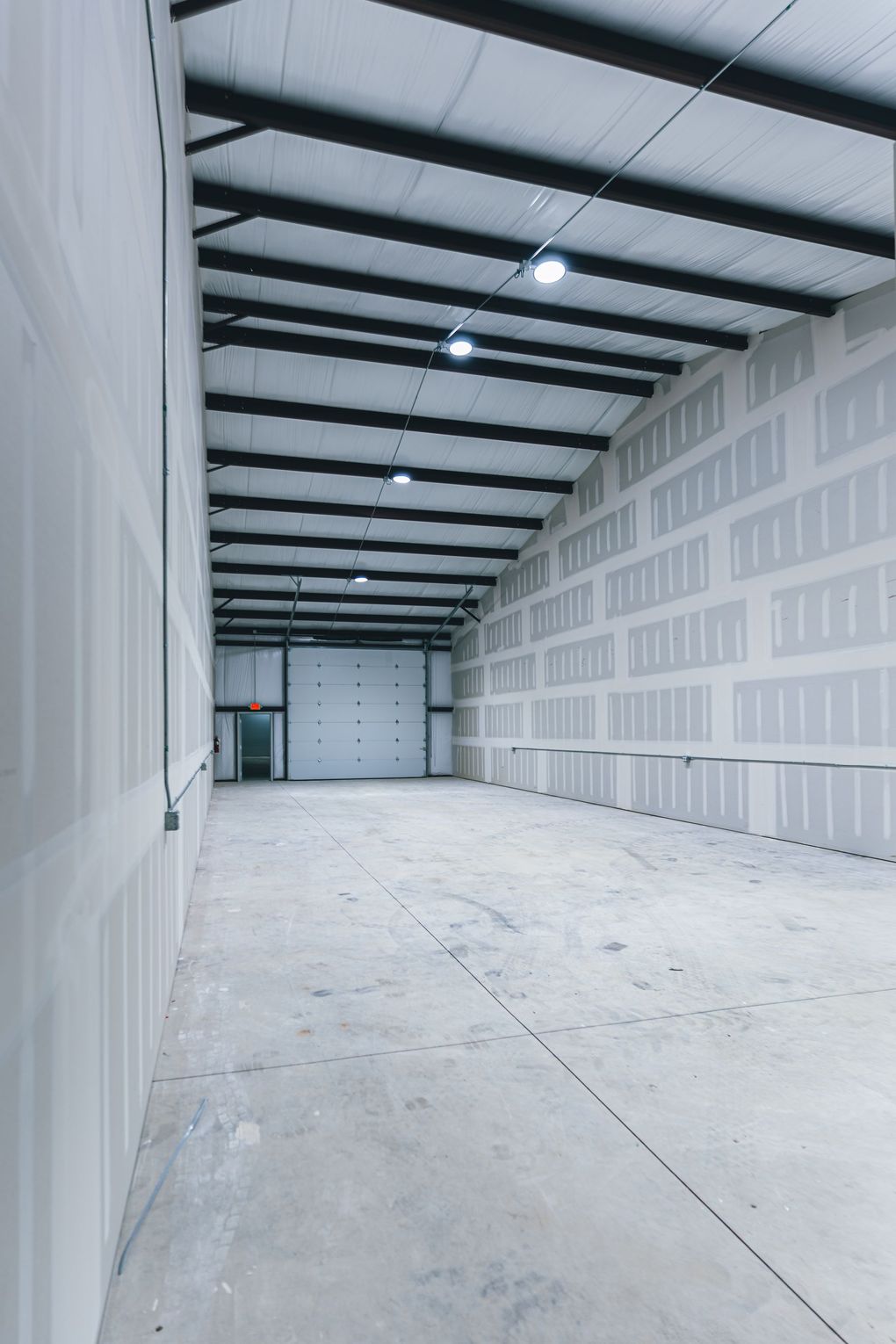 An orange truck is parked next to an office space in an empty garage