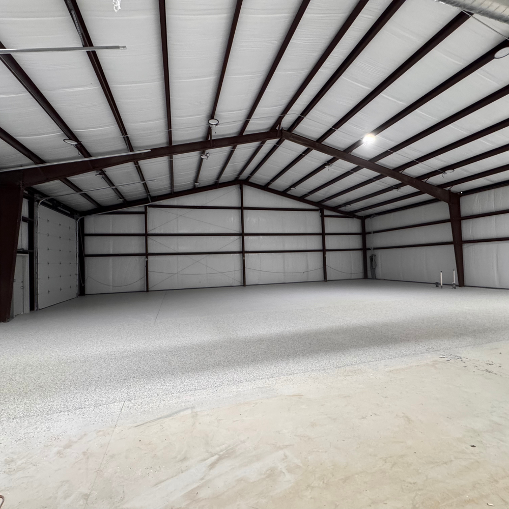 A large empty warehouse with a metal roof