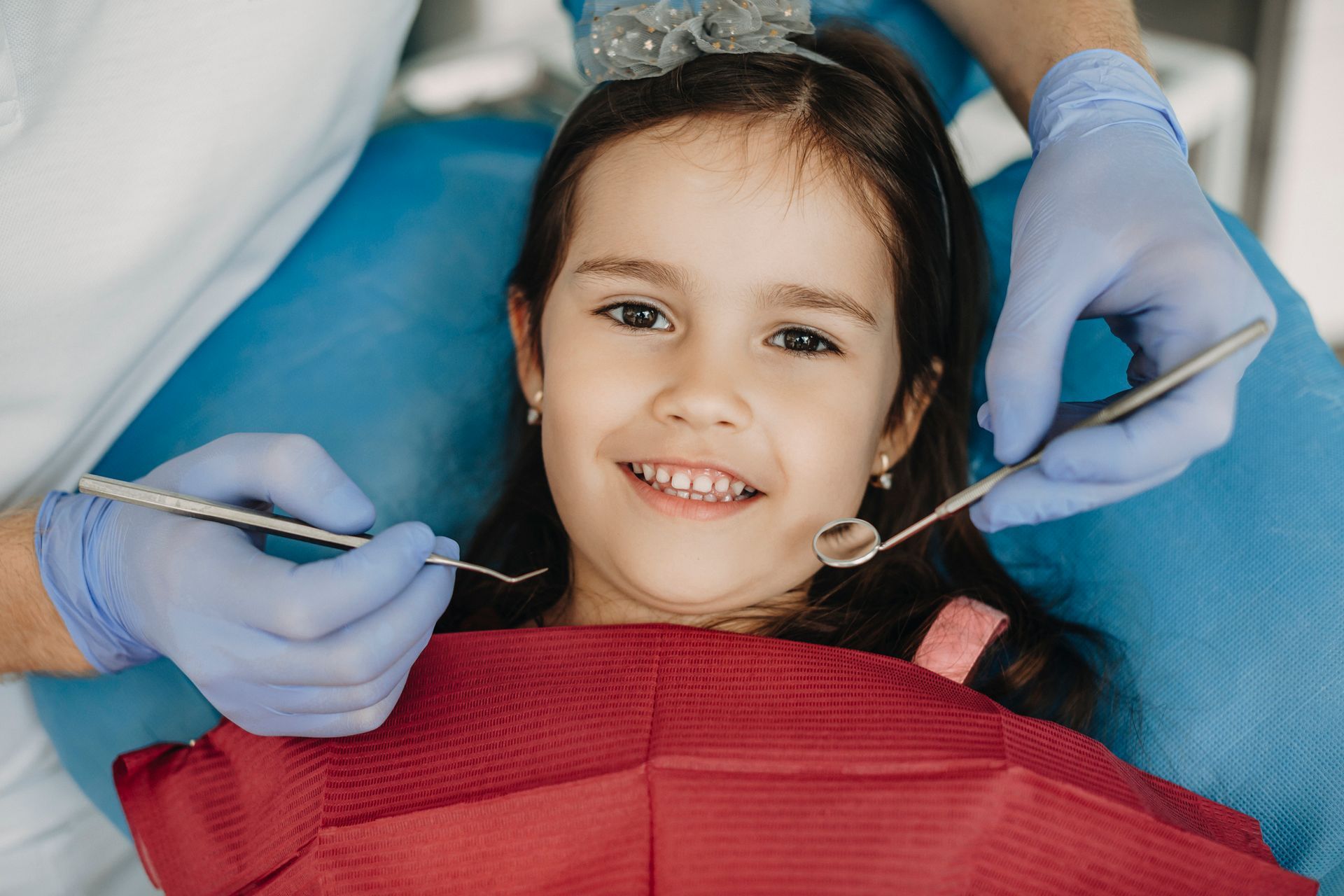 Girl smiling at dentist during a dental examination.