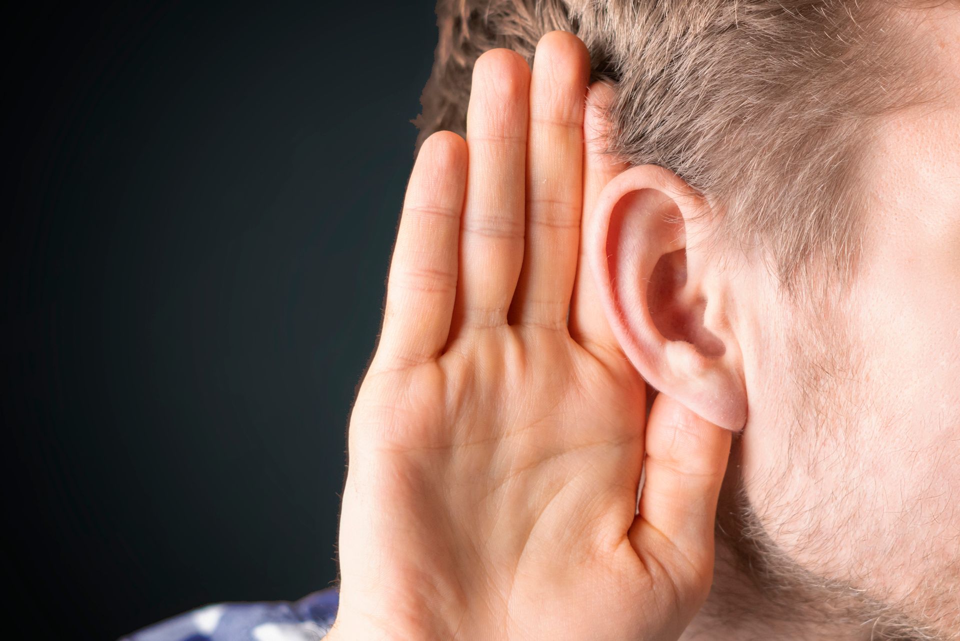 A person holding his hand to his ear A person holding his hand to his ear