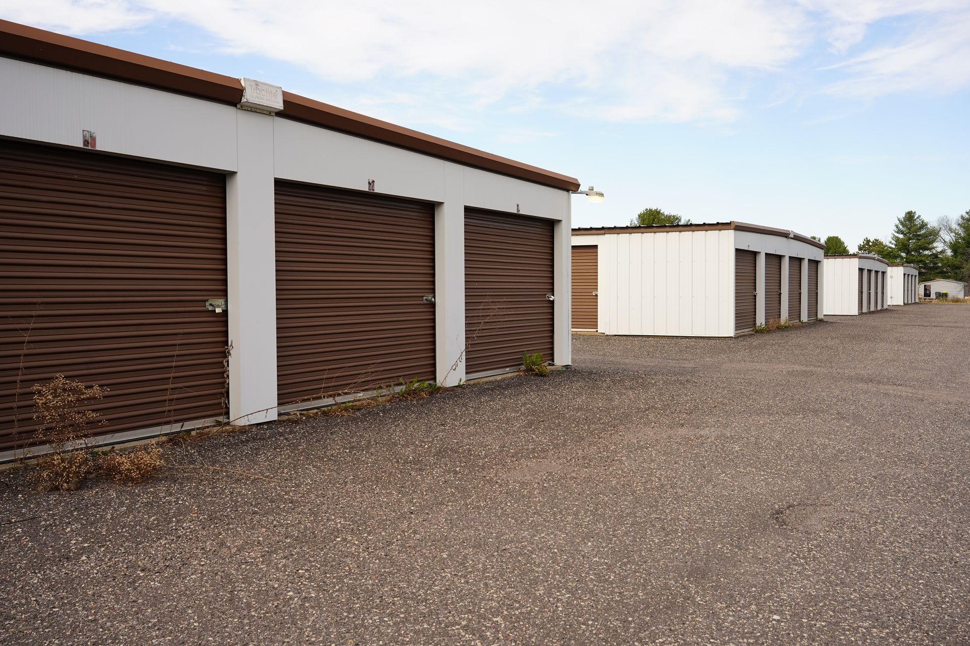 Row of storage units with closed roll-up doors.