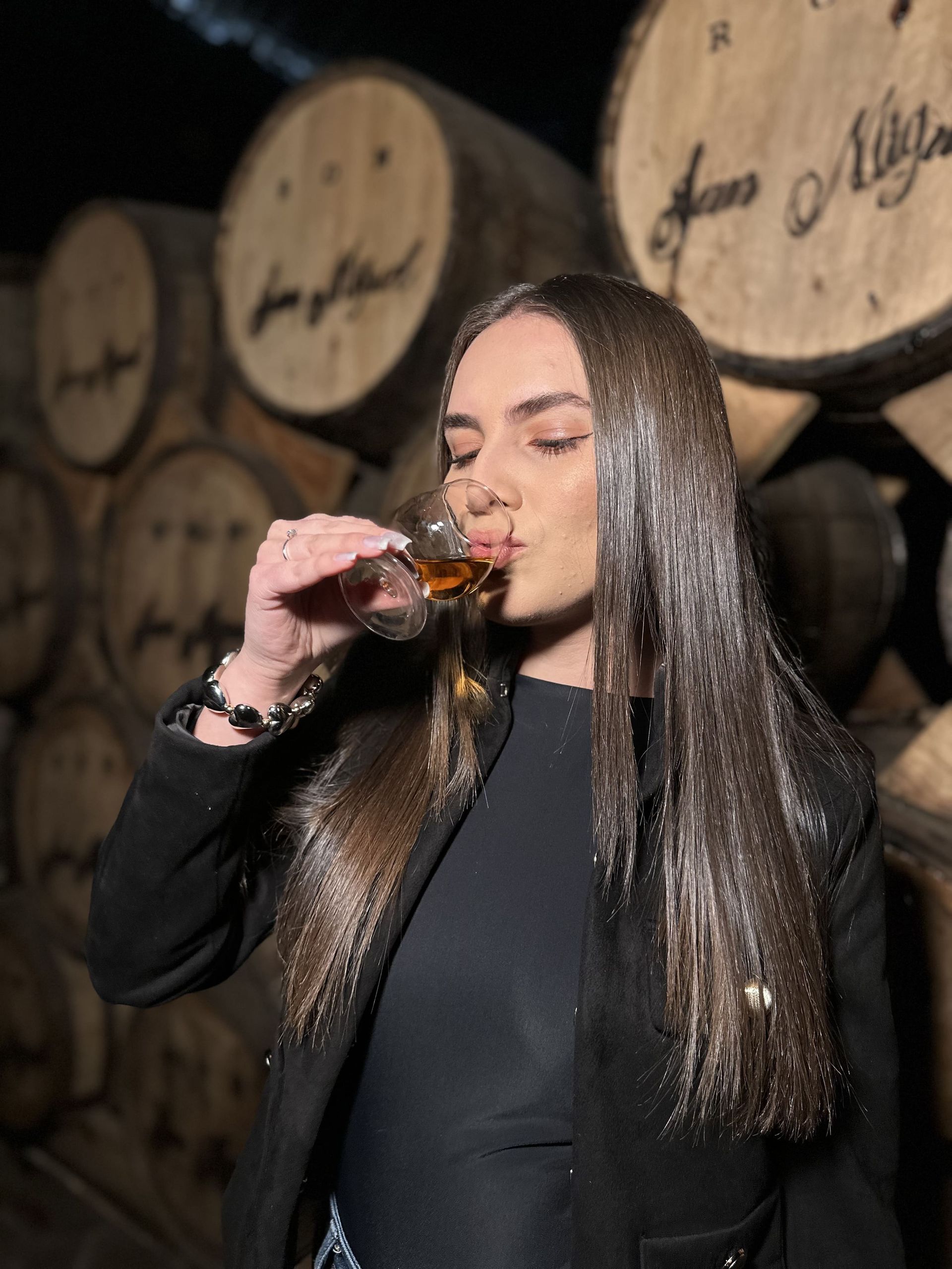 A man and a woman are standing next to a large wooden barrel.