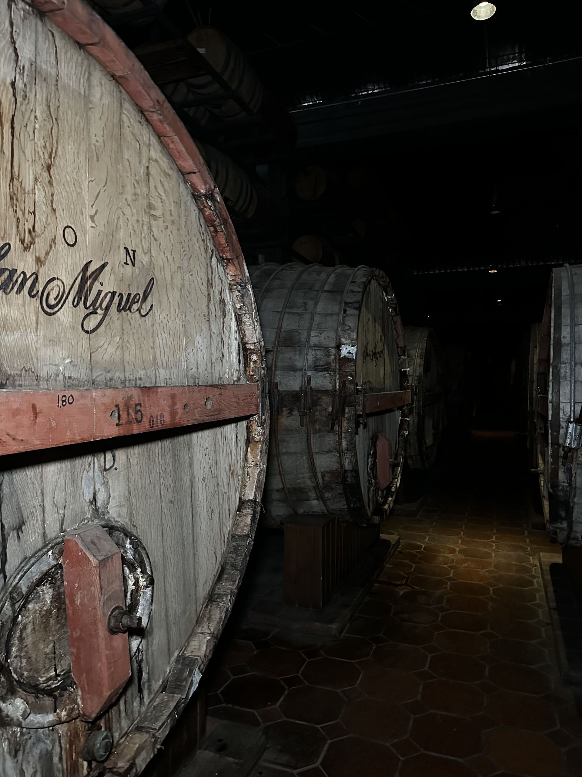 A man and a woman are standing next to a large wooden barrel.
