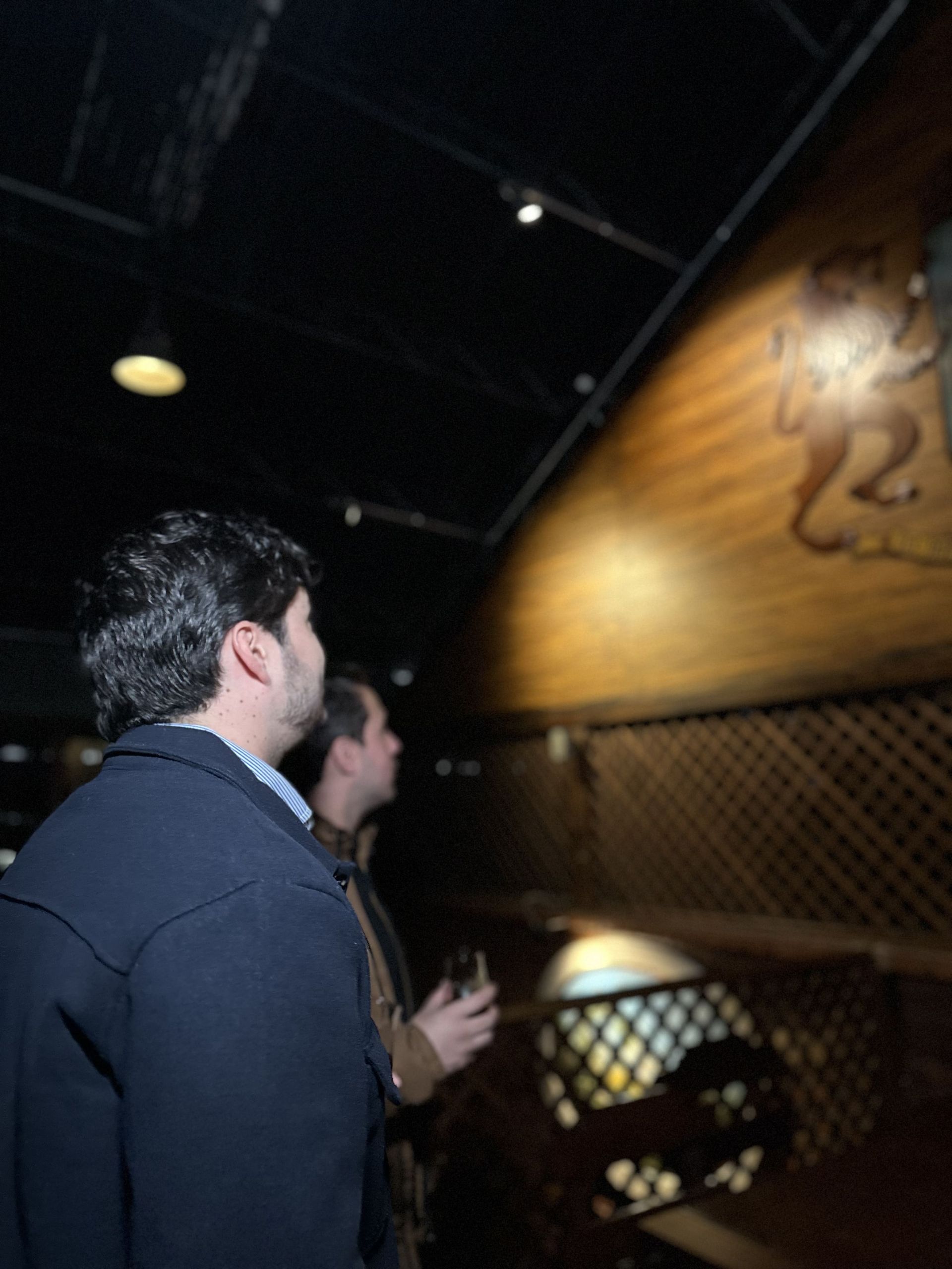 A man and a woman are standing next to a large wooden barrel.