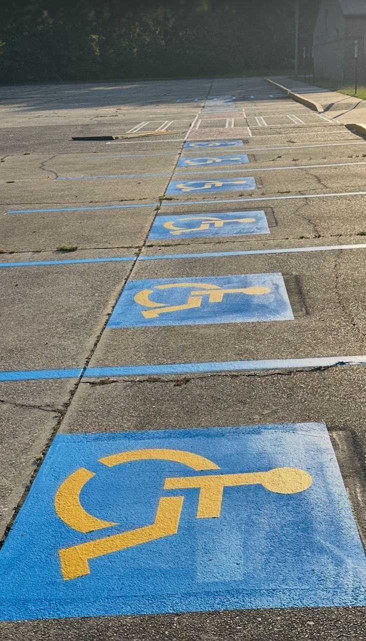Faded ADA parking lot striping in Chandler Arizona showing worn handicap symbols and lines needing restriping for safety and visibility