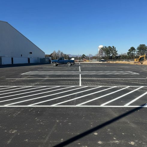 Professional parking lot striping at a gas station with clear yellow lines and numbered spaces