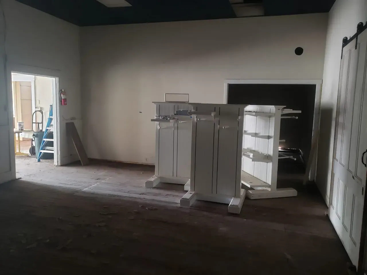 An empty room with shelves and a fire extinguisher