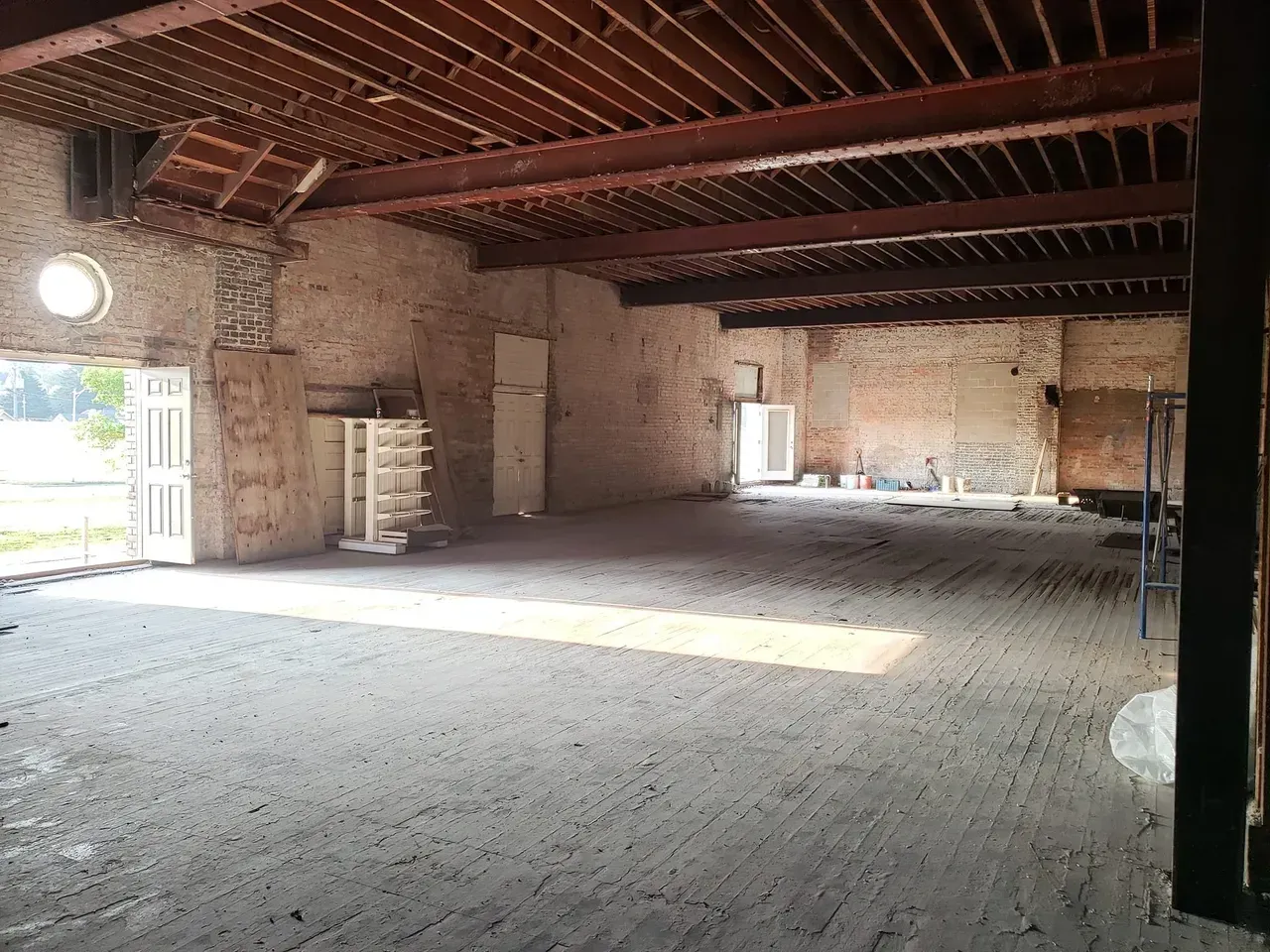 An empty room with a wooden ceiling and brick walls