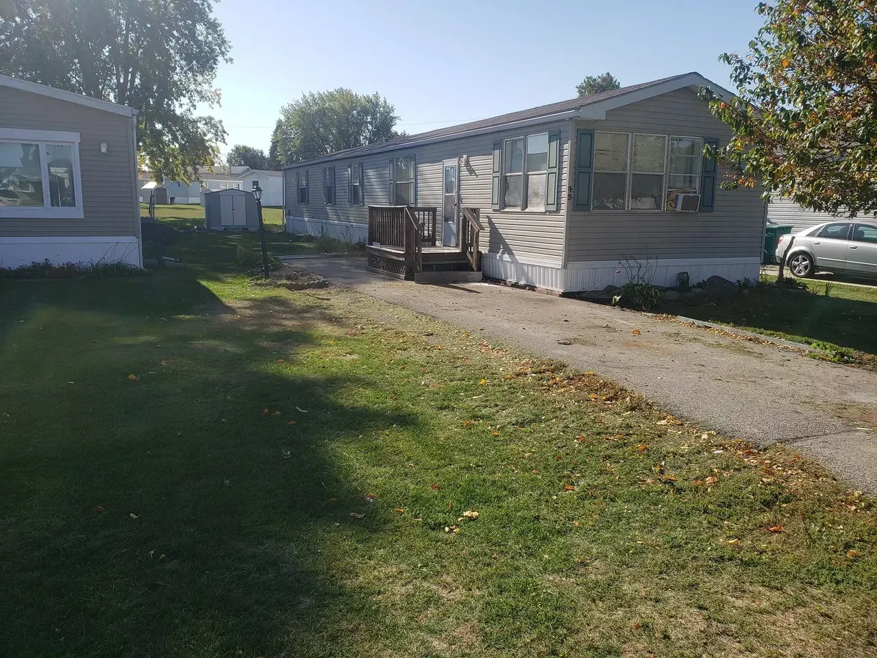 A couple of mobile homes are parked next to each other on a dirt road.