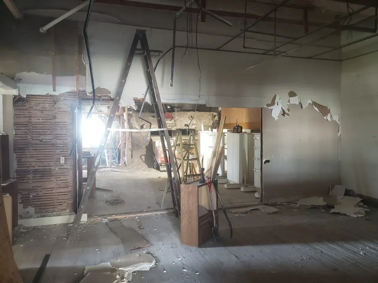 An empty room with a ladder hanging from the ceiling