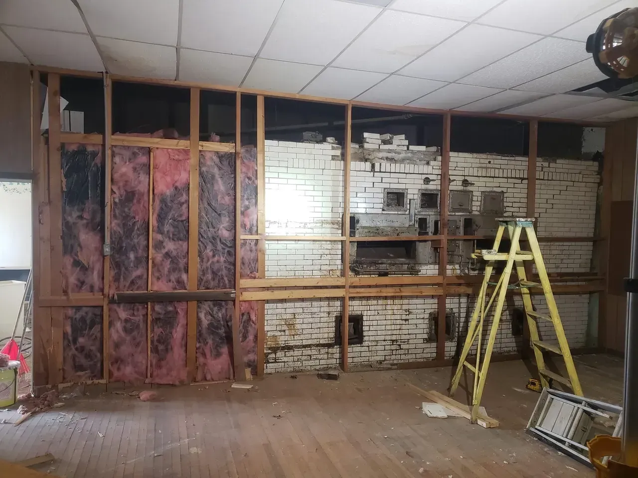A room with a ladder and a brick wall