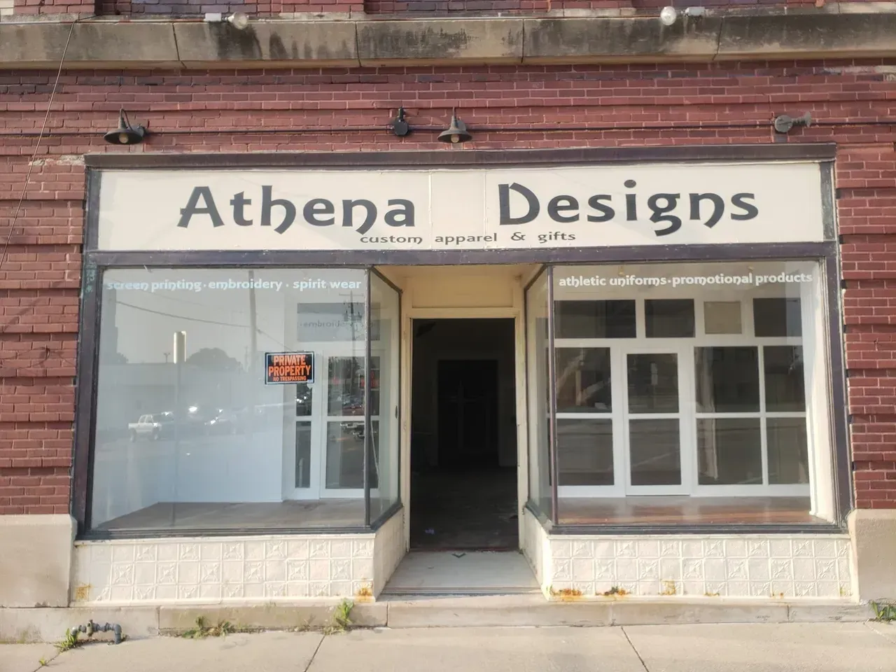 A brick building with a sign that says athena designs