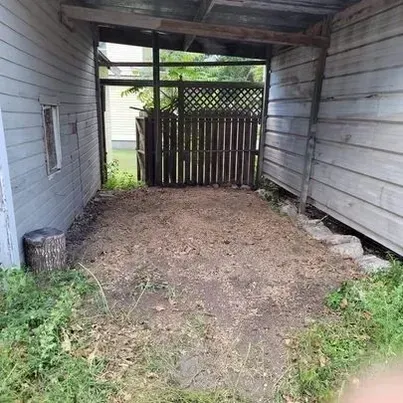 An empty garage with a wooden fence and a window.