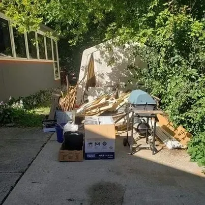 There is a lot of trash in the backyard of a house.