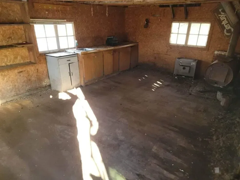 An empty room with a sink and a window