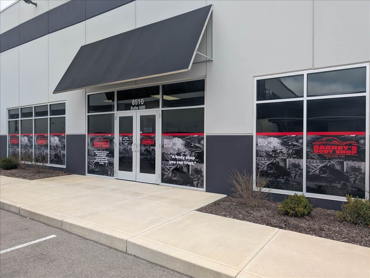 A large building with a lot of windows and a black awning.