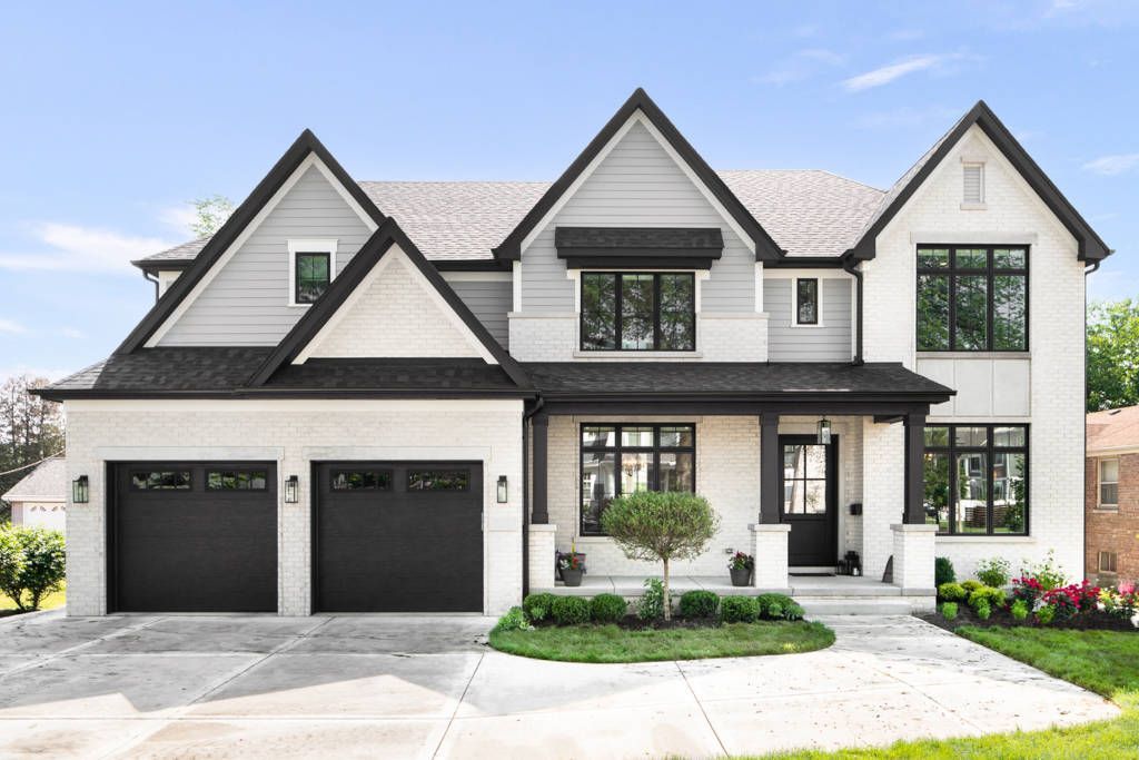 Two-story modern home with gray and white exterior, black trim, and a concrete driveway.