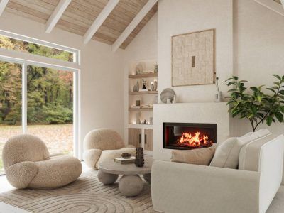 Cozy living room with fireplace, white walls, large window overlooking a forest, and neutral-toned furniture.