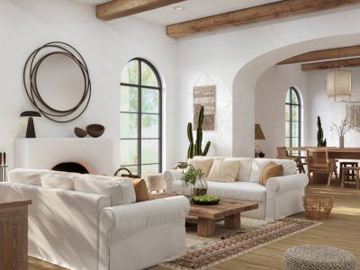 Bright living room with white sofas, wooden beams, a fireplace, and arched windows.