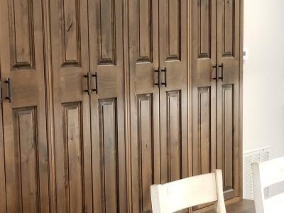 Wooden cabinet doors with black handles, installed in a room.