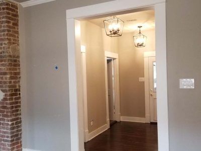 Interior doorway with white trim, gray walls, and exposed brick.
