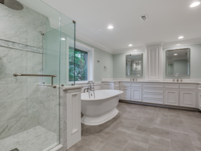 Spacious, bright bathroom with a shower, freestanding tub, double vanity, and gray tile floor.