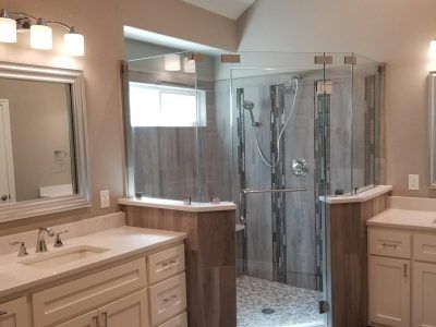 Bathroom with a large, glass-enclosed shower, two vanities, and light beige walls.