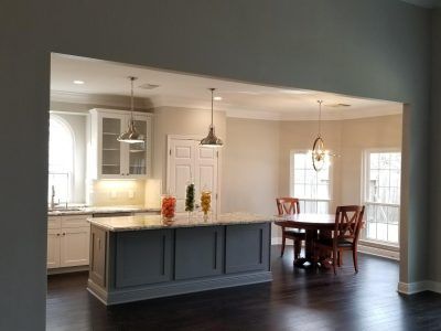Kitchen with island and dining area; gray cabinets, granite countertops, dark wood floor, pendant lights.