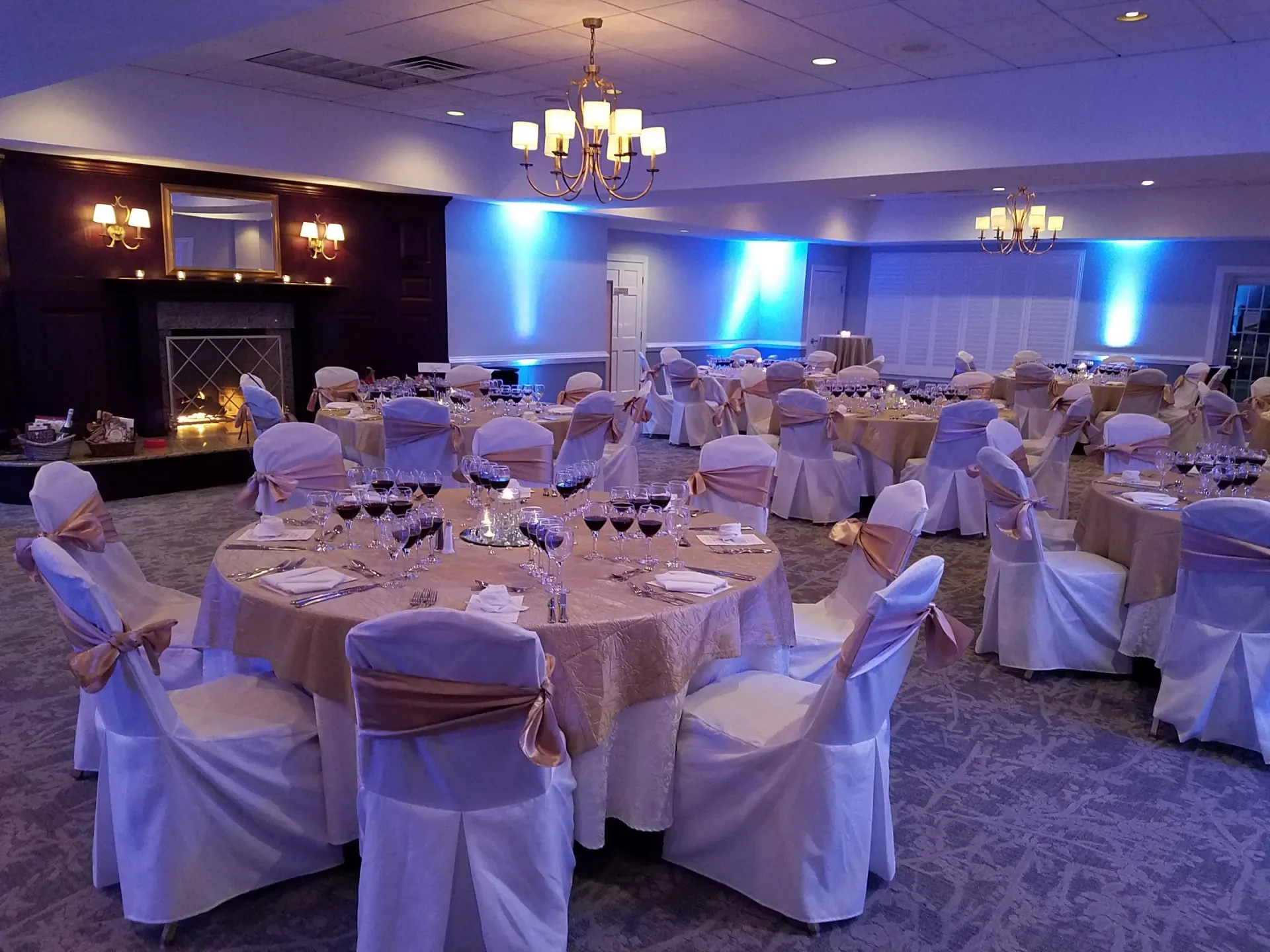 Formal banquet hall set for an event with round tables, chairs, and centerpieces.