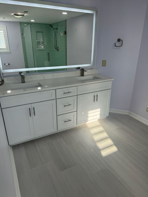 A bathroom with two sinks and a large mirror.