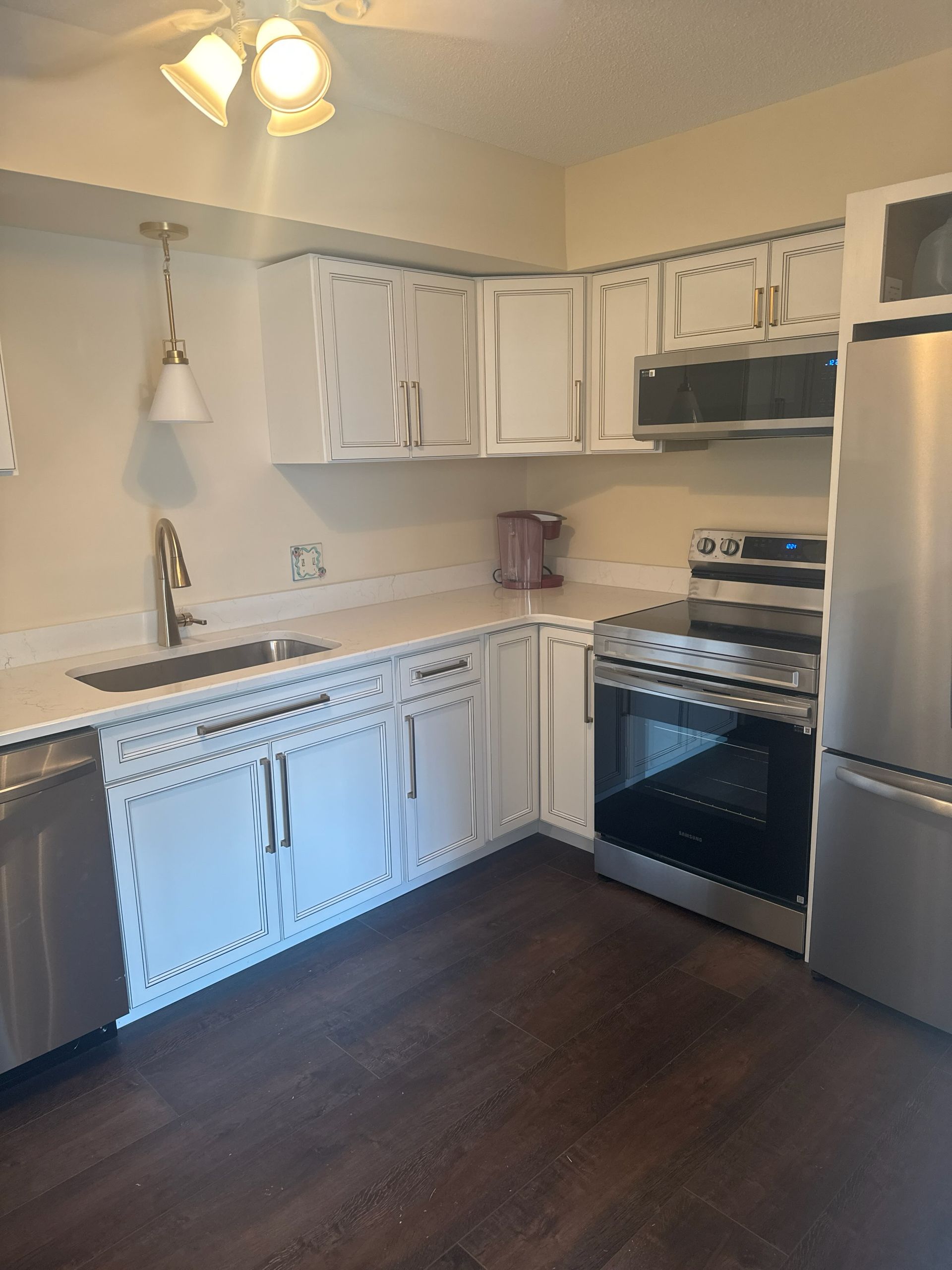 A kitchen with white cabinets and stainless steel appliances