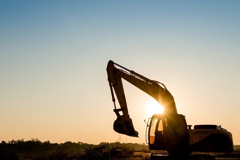 excavator with sunset in the background