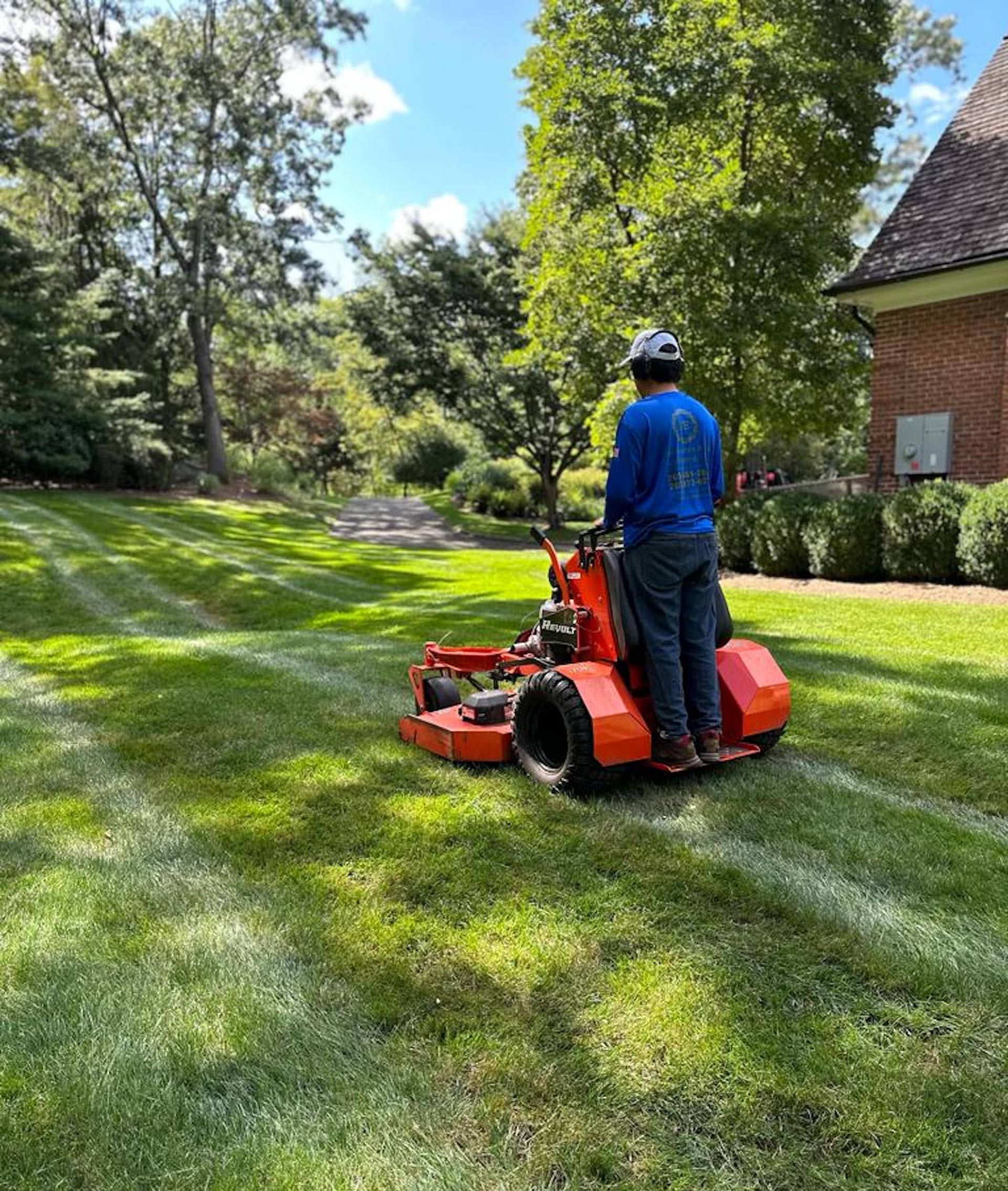 A man is riding a lawn mower on a lush green lawn