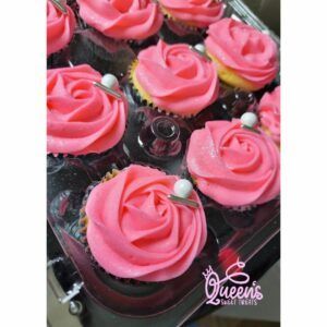 A box of pink frosted cupcakes with pearls on top