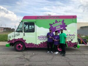 A group of people are standing in front of a food truck.