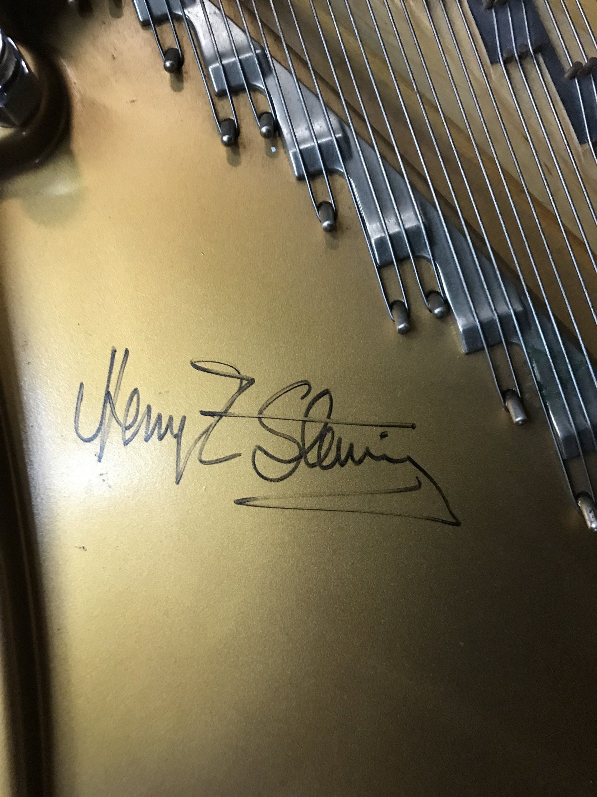a close up of a piano with a signature on it